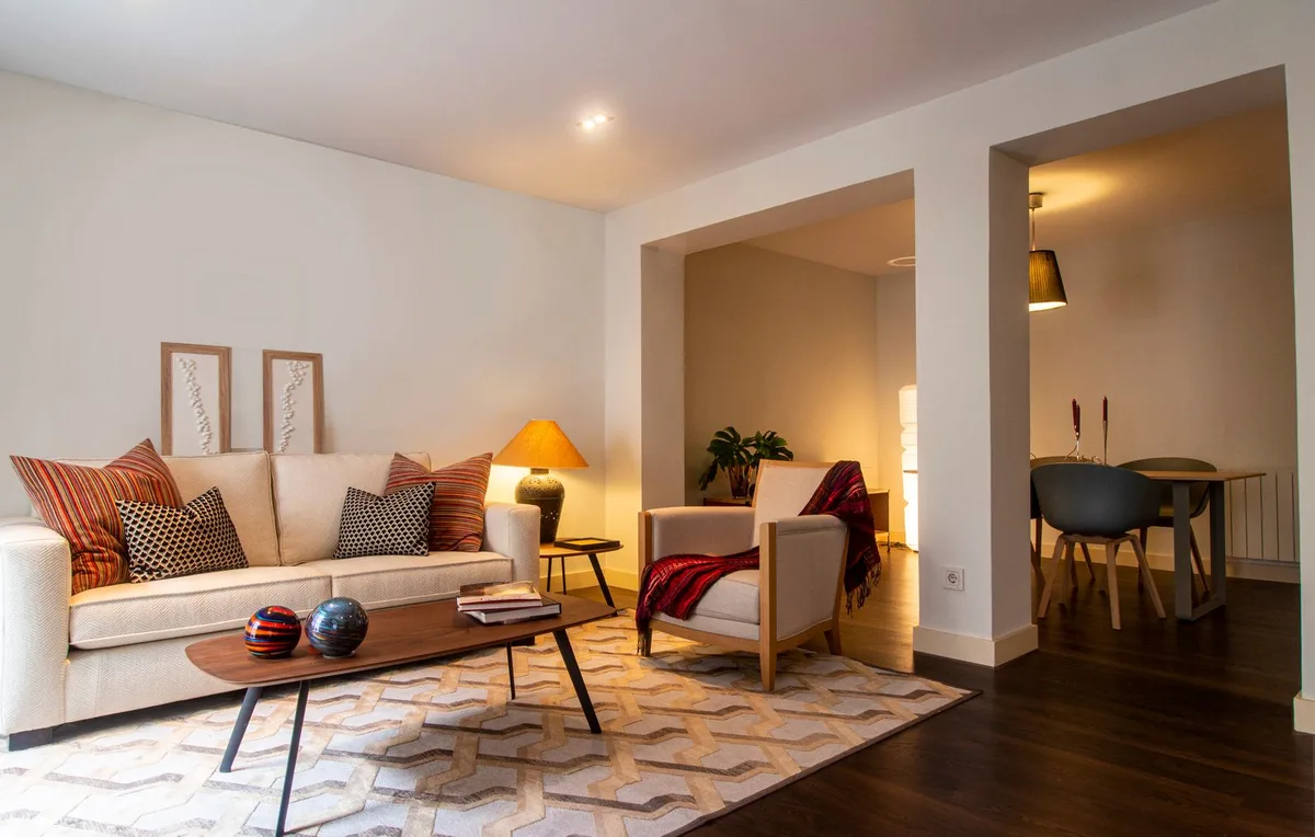 Cozy contemporary living room with warm ambient lighting against deep blue twilight windows